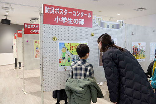 展示された絵を見る親子