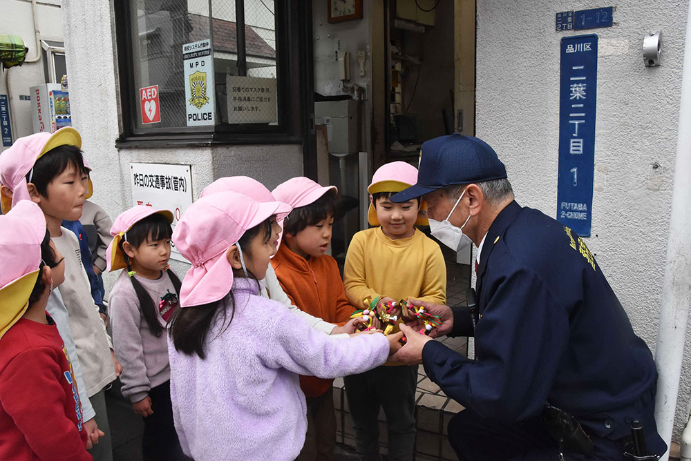 双葉町交番でリースを渡す園児たち