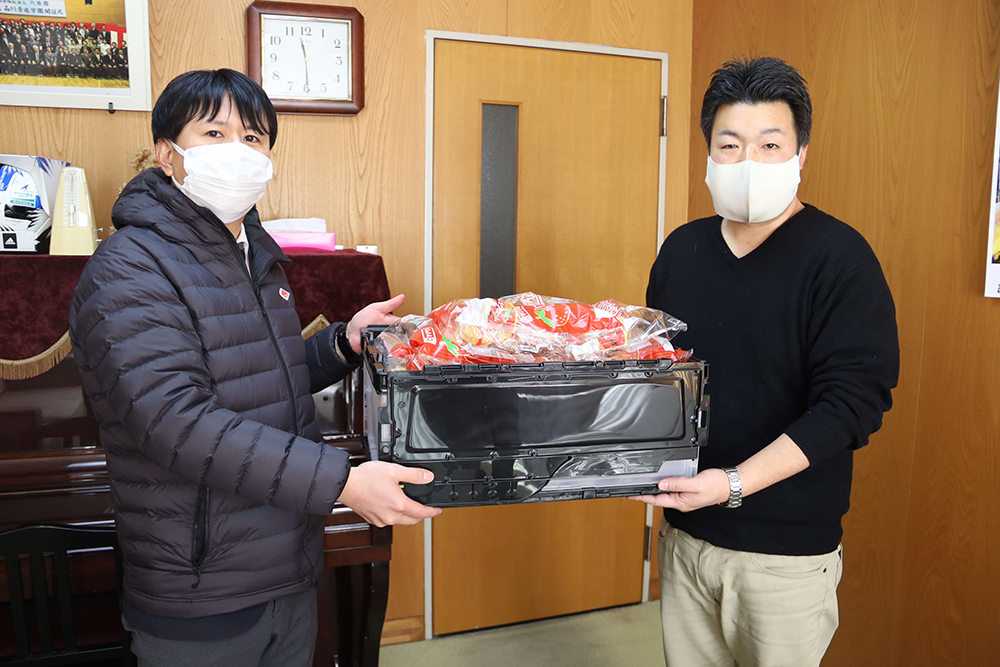 景徳学園の職員にケーキ菓子を手渡し