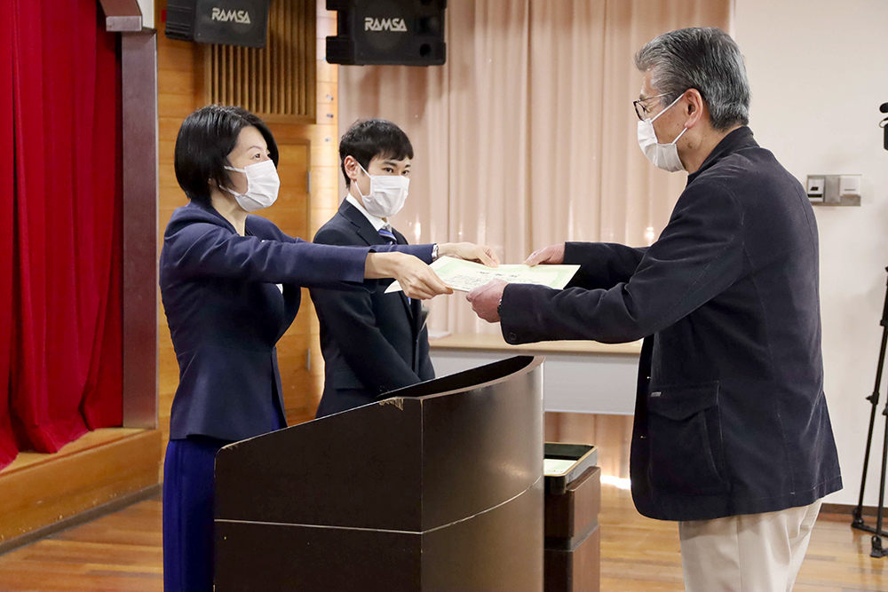 一人ひとりに感謝状を渡す区長