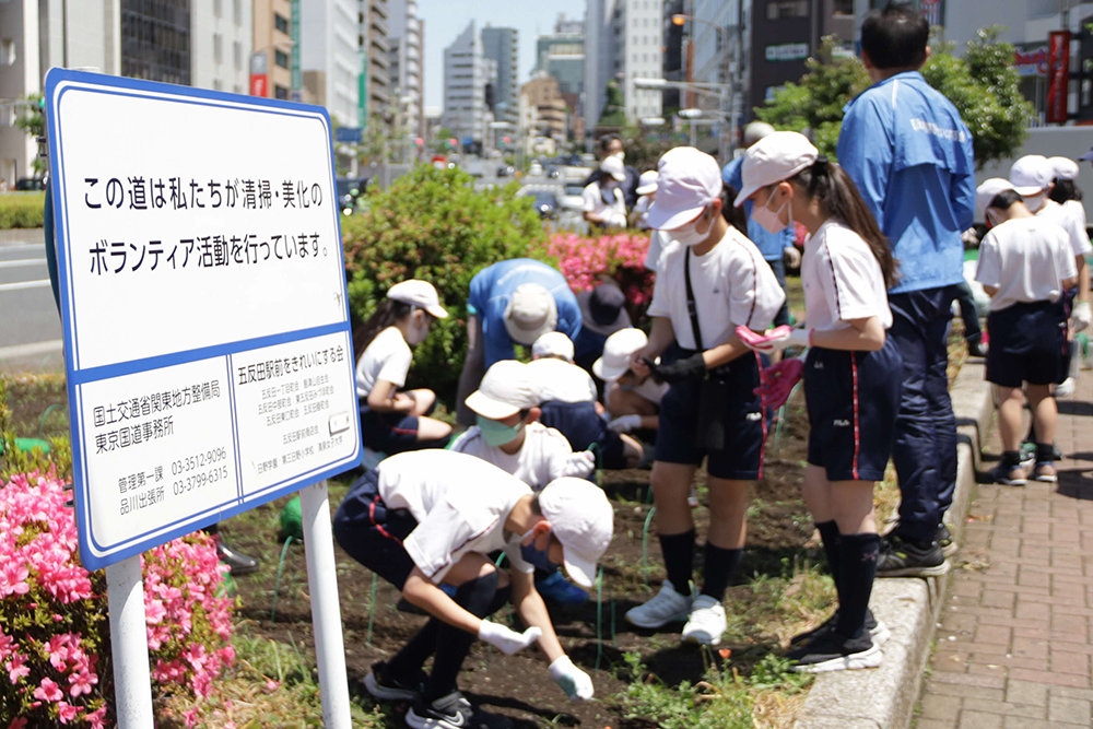 きれにする会の看板と児童たち