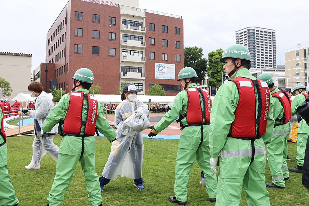 大井消防団と大崎高校の生徒が土のうリレー