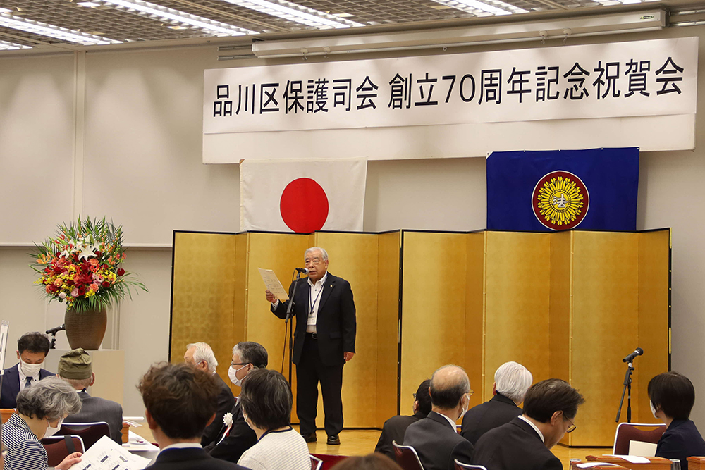 記念祝賀会であいさつする品川区民生委員協議会 田尻会長