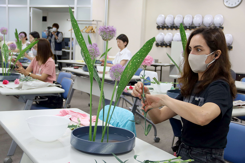 真剣な表情で花と向き合う女性