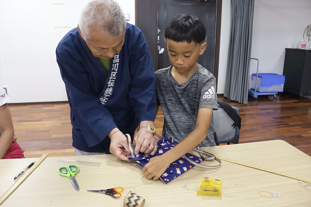 作業する子どもとサポートする剱持さん