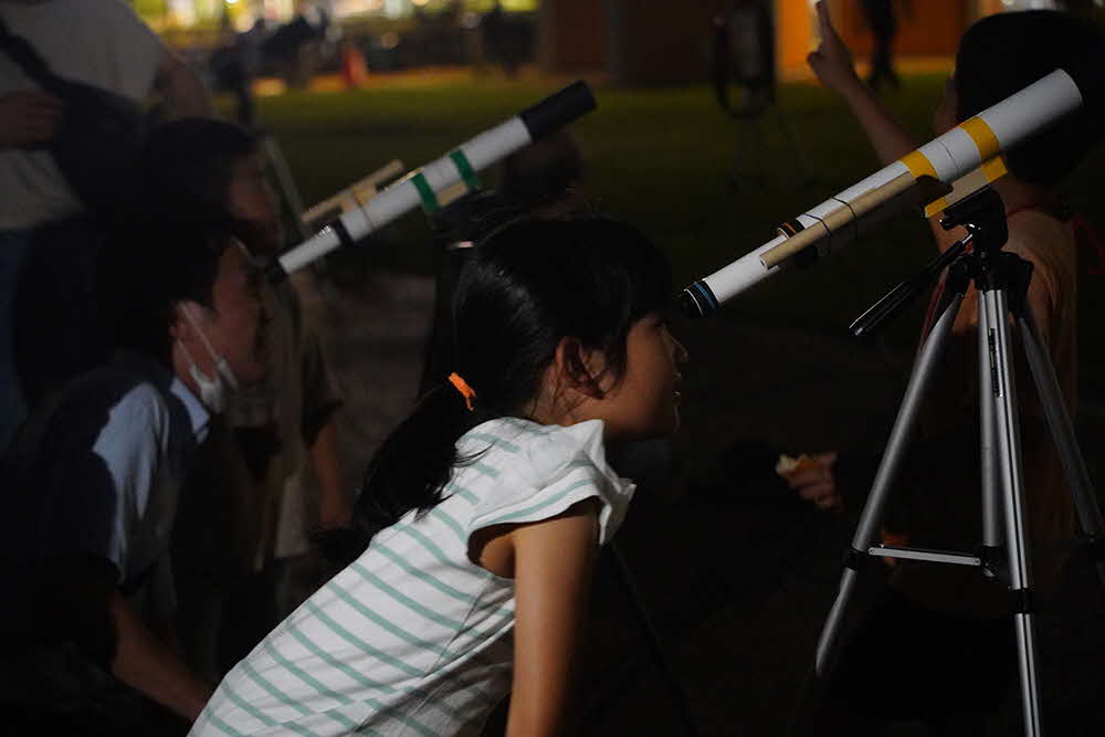 望遠鏡をのぞく子どもたちの画像