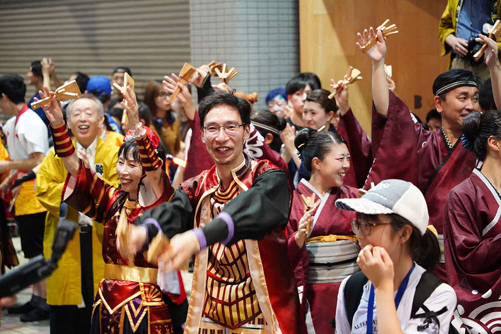 笑顔で踊る男性たちの画像