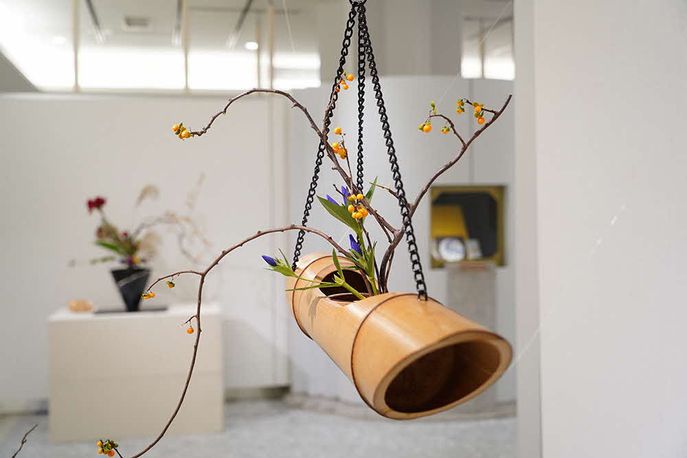 竹で作ったプランターに花を植えている作品の写真