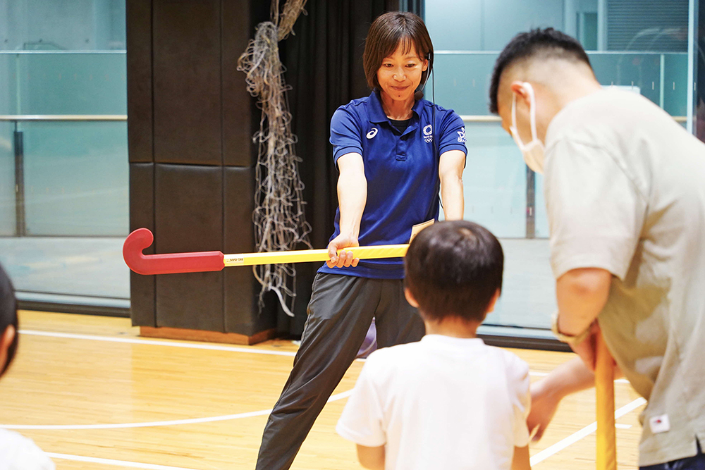 スティックの持ち方を教える藤尾さんの画像