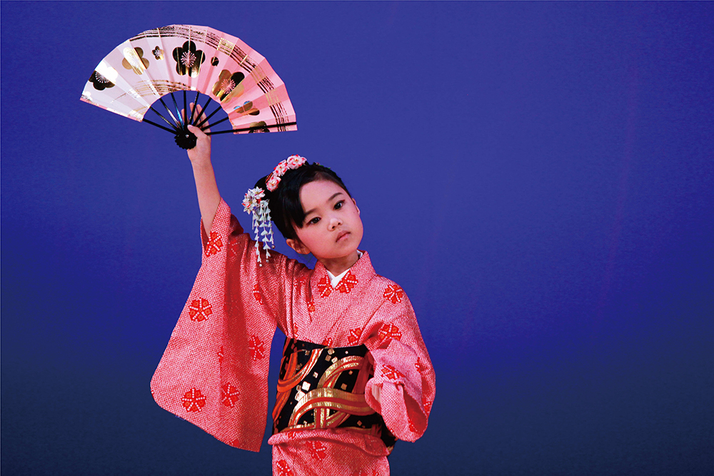 扇子を持ちポーズを決める女の子の画像