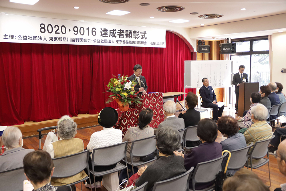 品川歯科医師会の会長があいさつする会場広めの画像