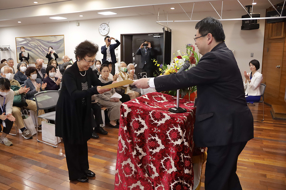 品川歯科医師会の会長が表彰状を渡す画像