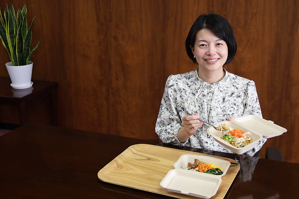 SDGs丼を持って笑顔を見せている区長の画像