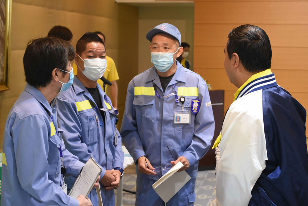 清掃事務所の職員と大使館職員とが打ち合わせしている様子の写真