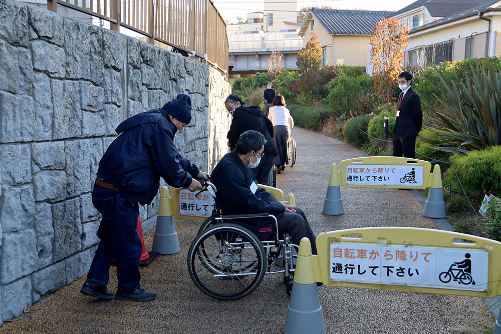 車いすで後ろ向きでスラロームを下っている画像