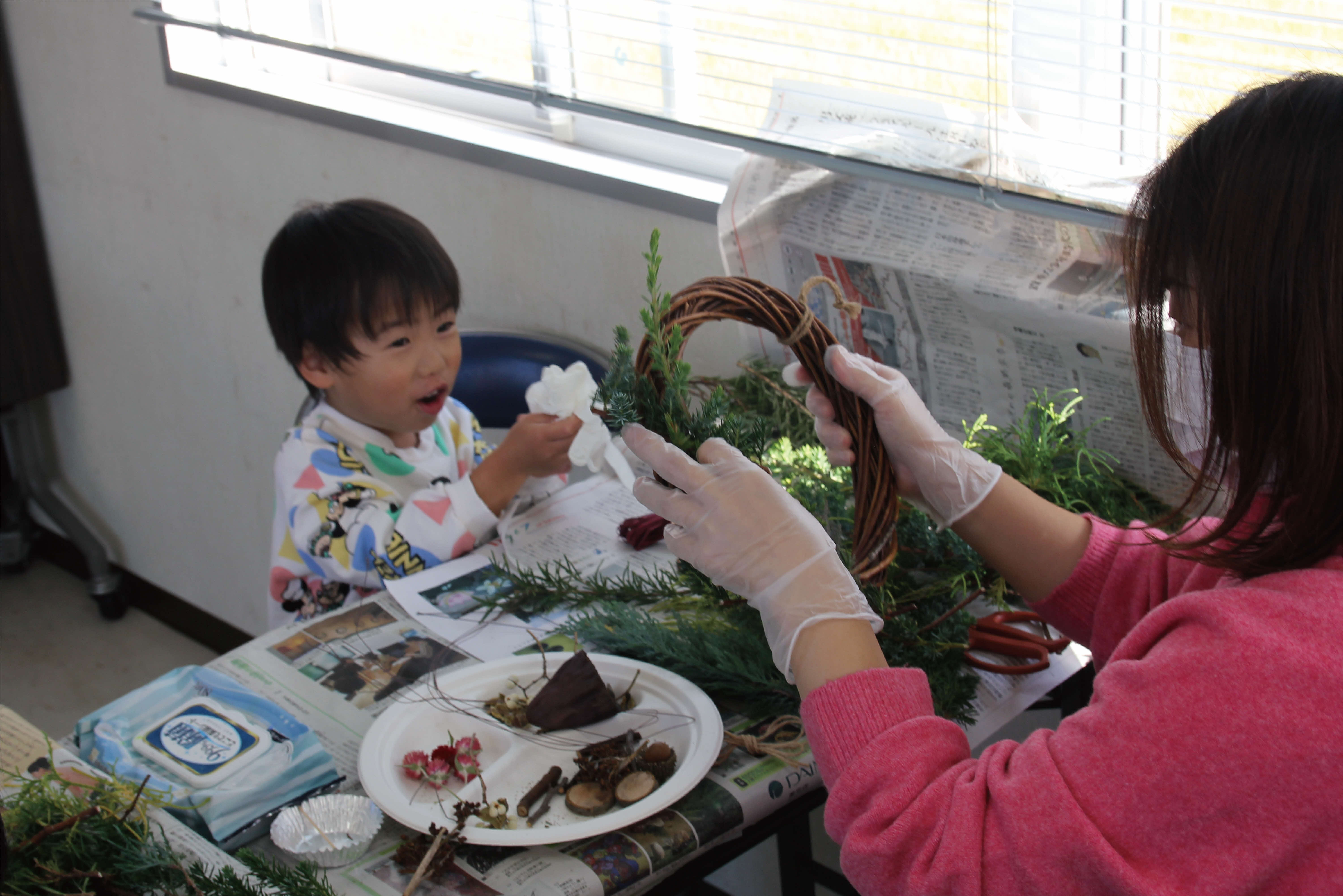 リースの輪に植物を巻き付けている写真