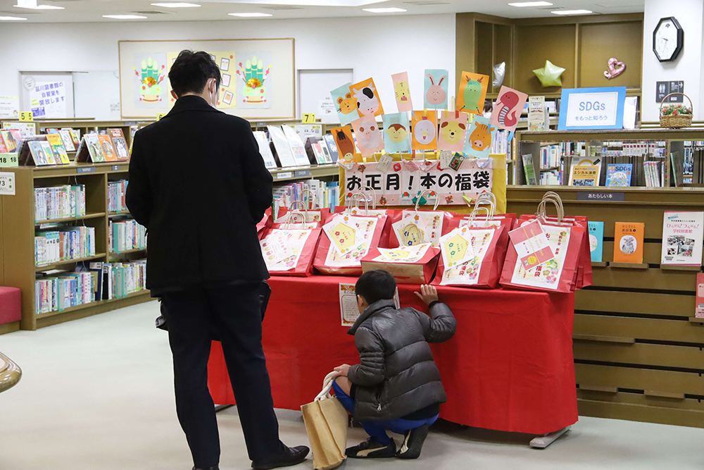 福袋を選ぶ親子の後ろ姿の画像