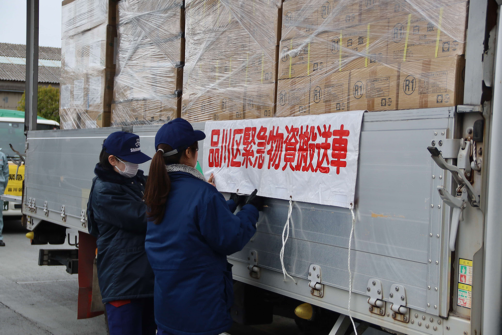 緊急物資搬送車両と書かれた幕を取り付けている画像