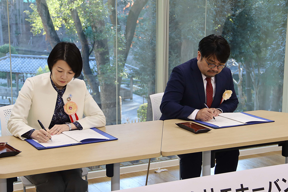 協定書にサインをしている区長と佐藤代表の画像
