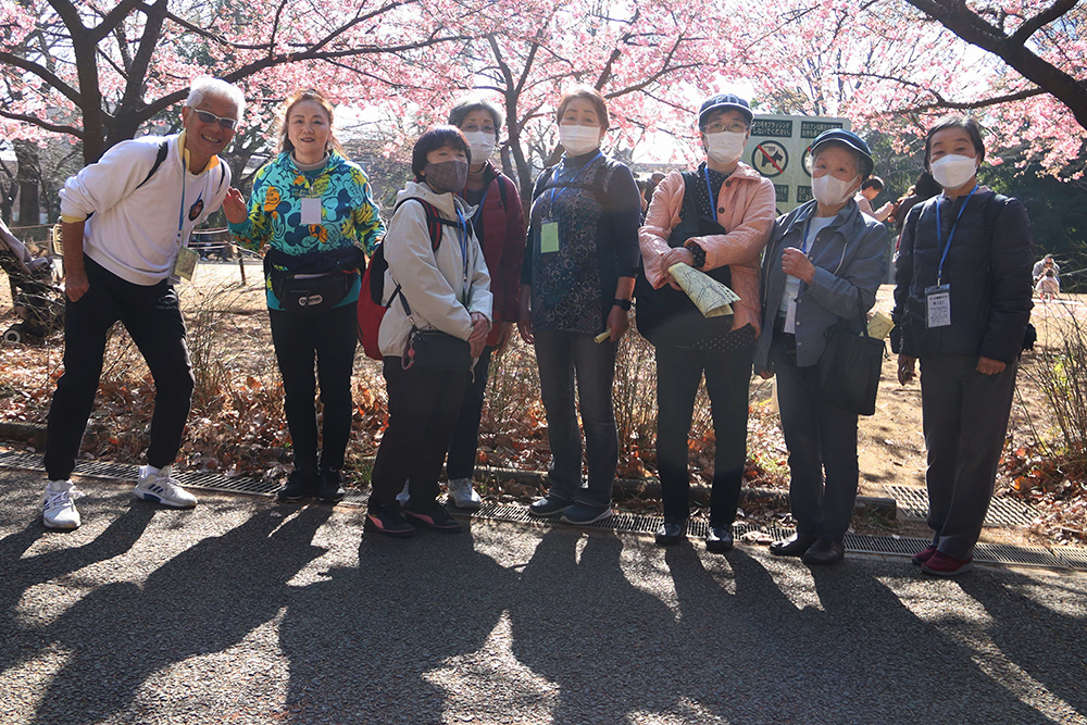 河津桜の前で記念撮影する様子の画像