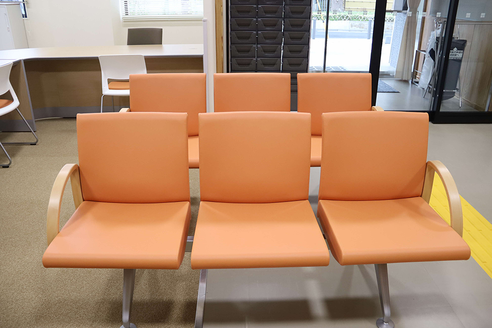 オレンジ色の椅子が並んだ待合室の画像
