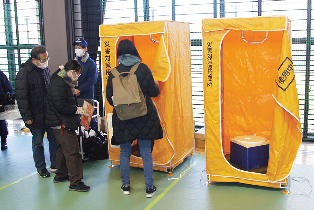 災害時用トイレを確認する親子も画像