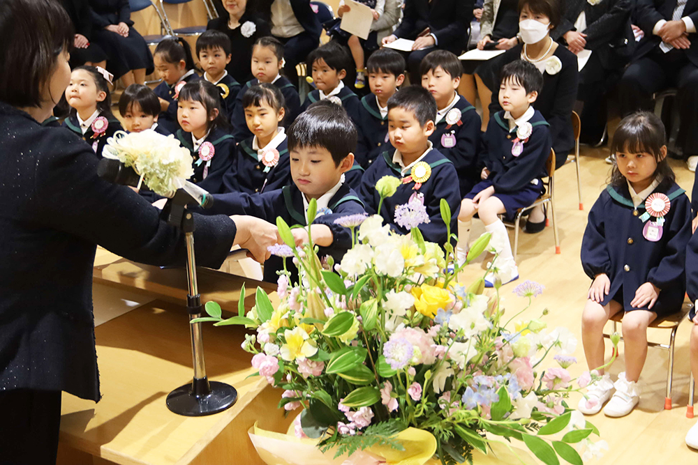 修了証賞を渡す延長と受け取る修了児の画像