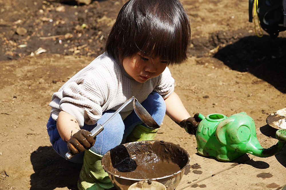 どろんこ遊びを楽しむ子どもの画像