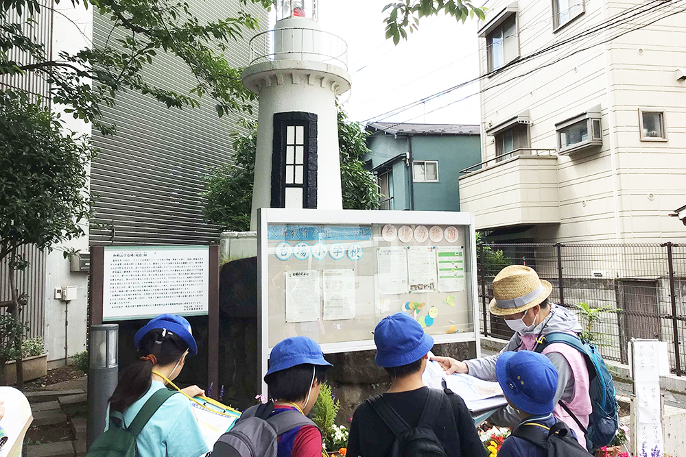 台場小学校の灯台について説明を聞く児童の画像