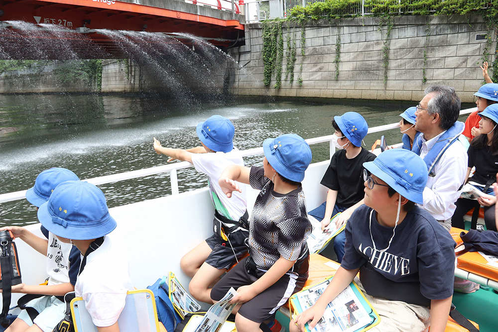 御成橋の散水を見学する児童たちの画像