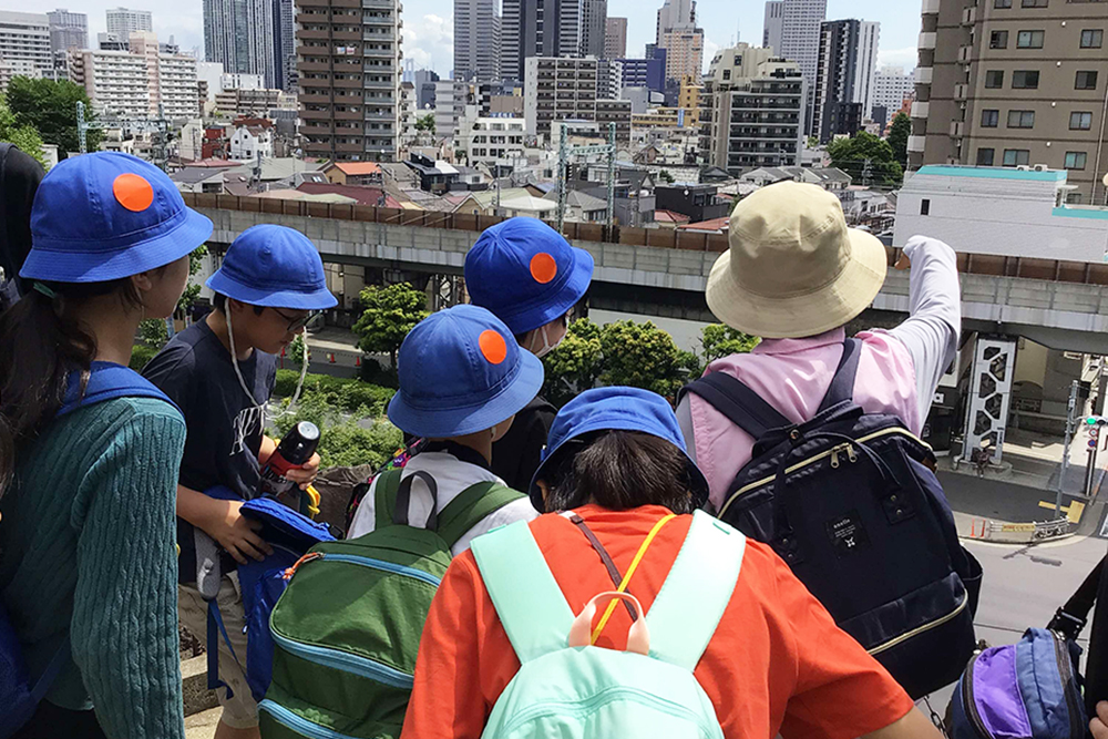 品川神社から街並みを見る児童の画像