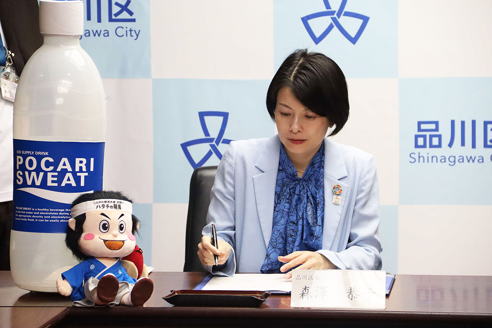 協定書にサインする森澤区長の画像