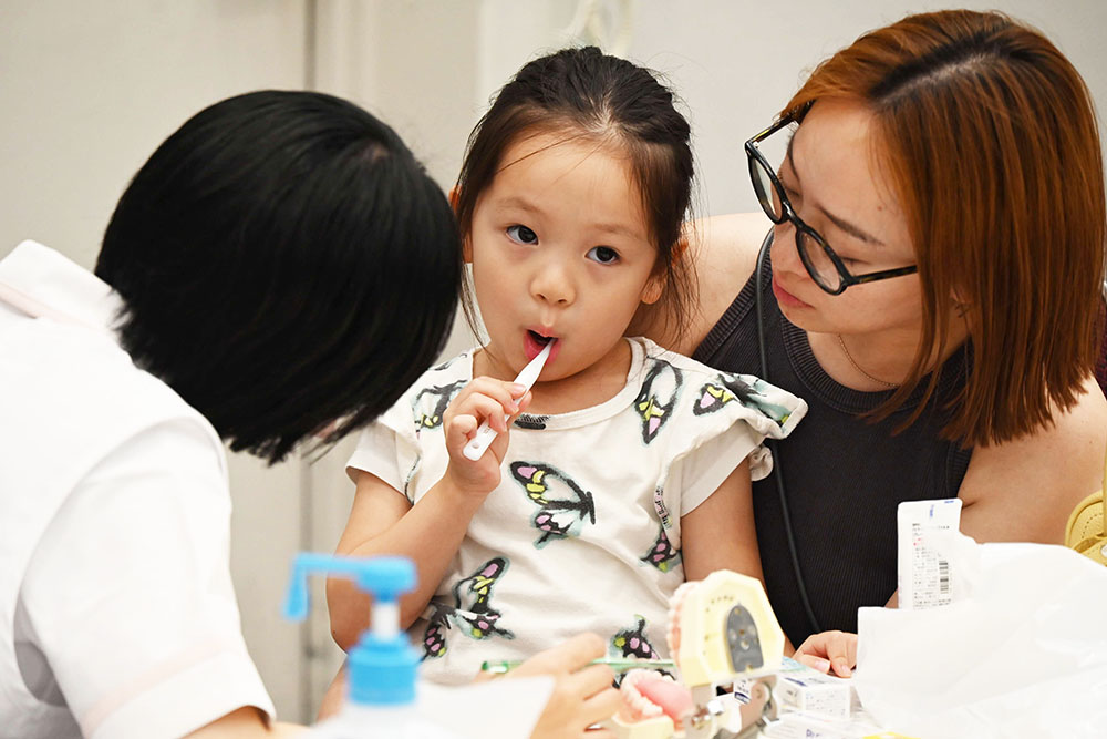 歯磨きのレクチャーをうける子どもの画像