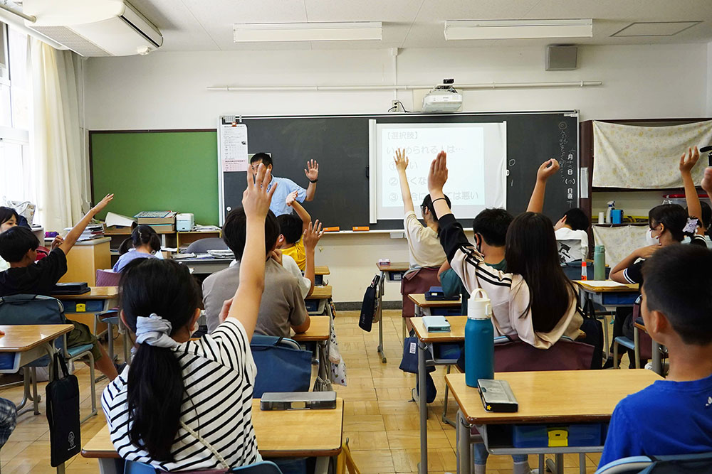 授業で挙手をする児童の画像
