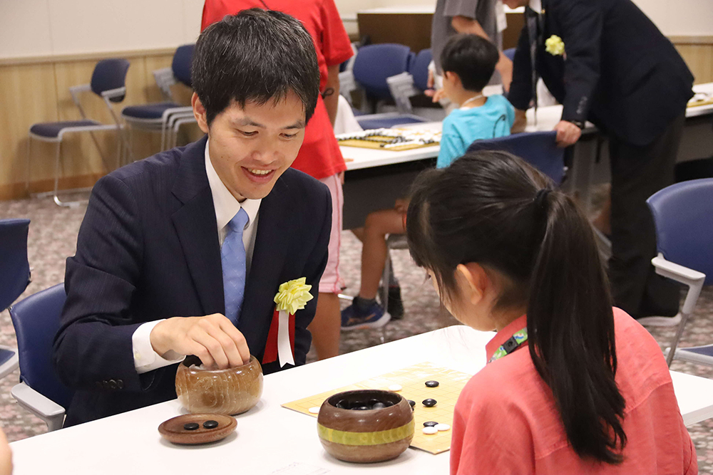 指導棋士の安斎八段と参加者の画像