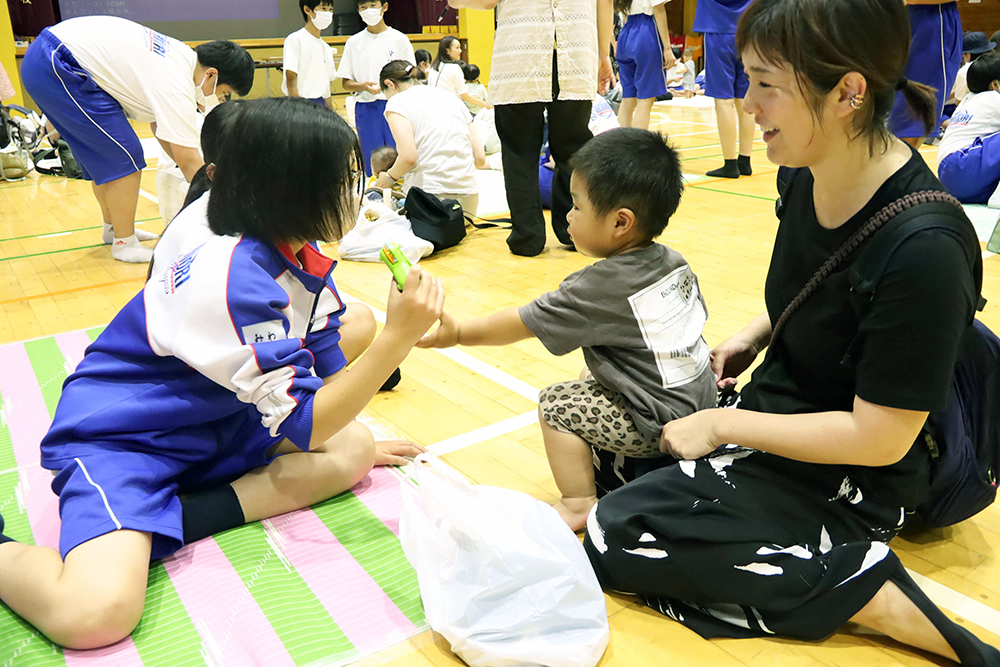 おもちゃで赤ちゃんと遊ぶ生徒の画像