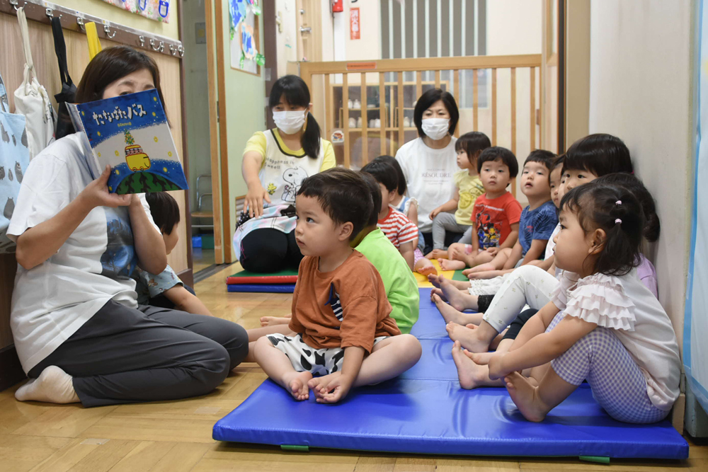 絵本を読んでもらっている様子の写真