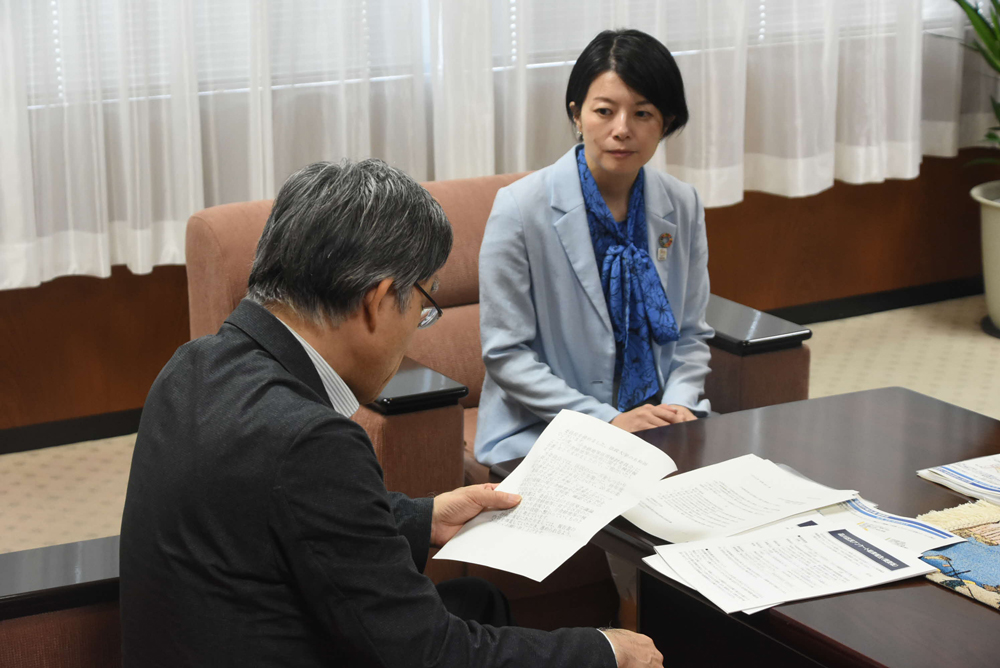 報告を聞いている様子の写真