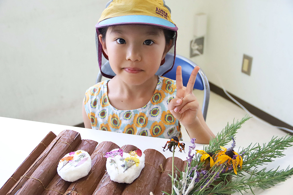 完成品を持って写真撮影する子どもの画像