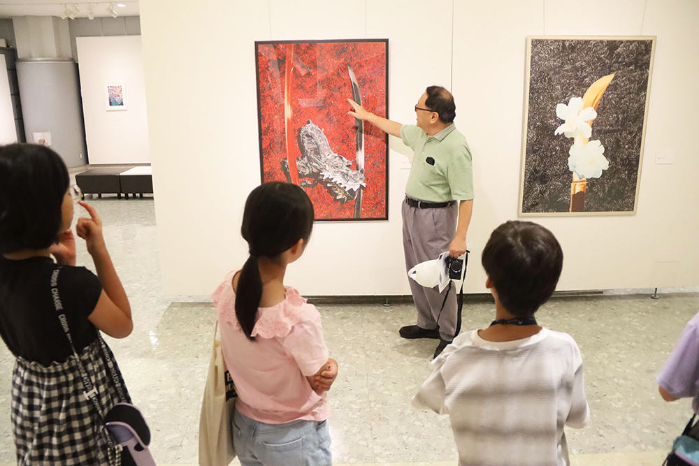 作品について説明するアーティストの画像
