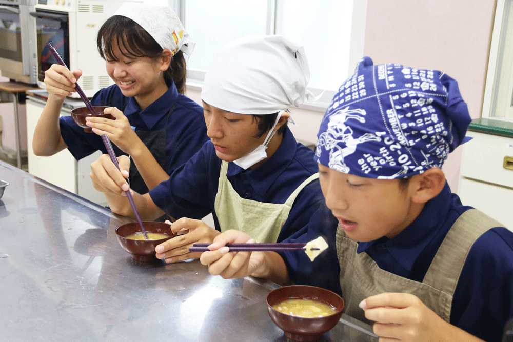 味噌汁を楽しそうにたべる生徒たち