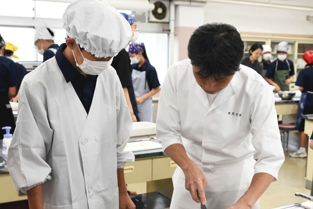 ねぎの切り方を笠原さんに学ぶ男子生徒