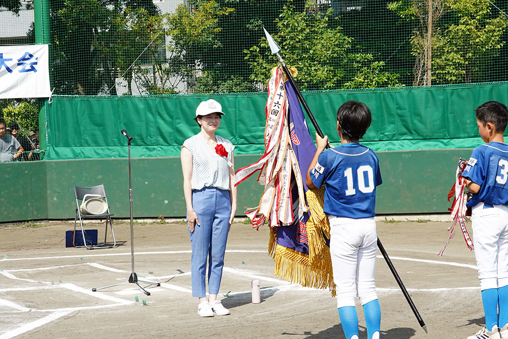 優勝旗と区長杯をもって挨拶している写真