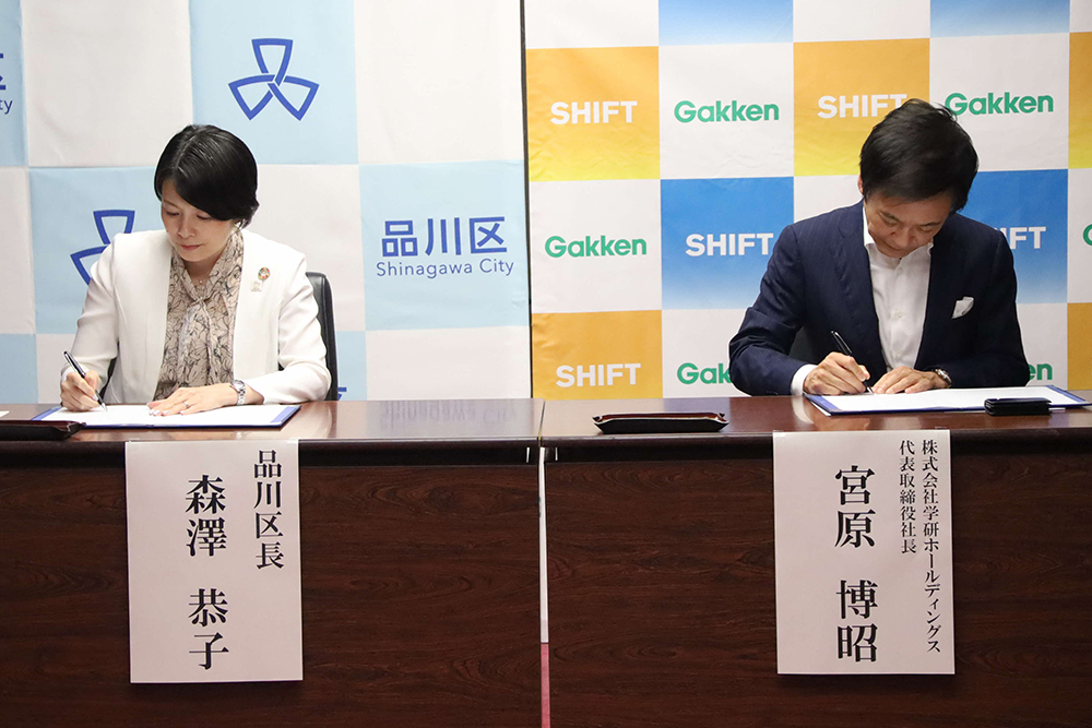 協定書に署名する森澤区長と宮原代表取締役の画像
