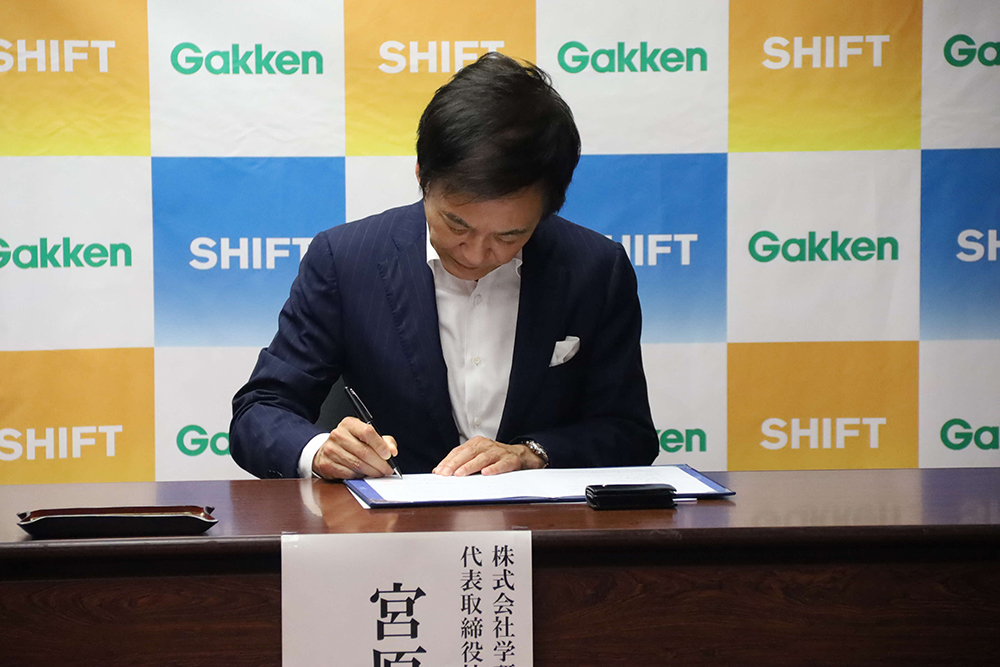 協定書に署名する宮原代表取締役の画像