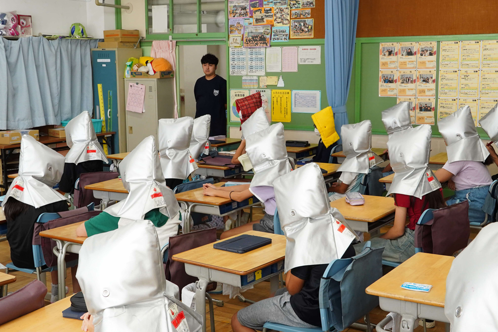 防災頭巾をかぶっている様子の写真