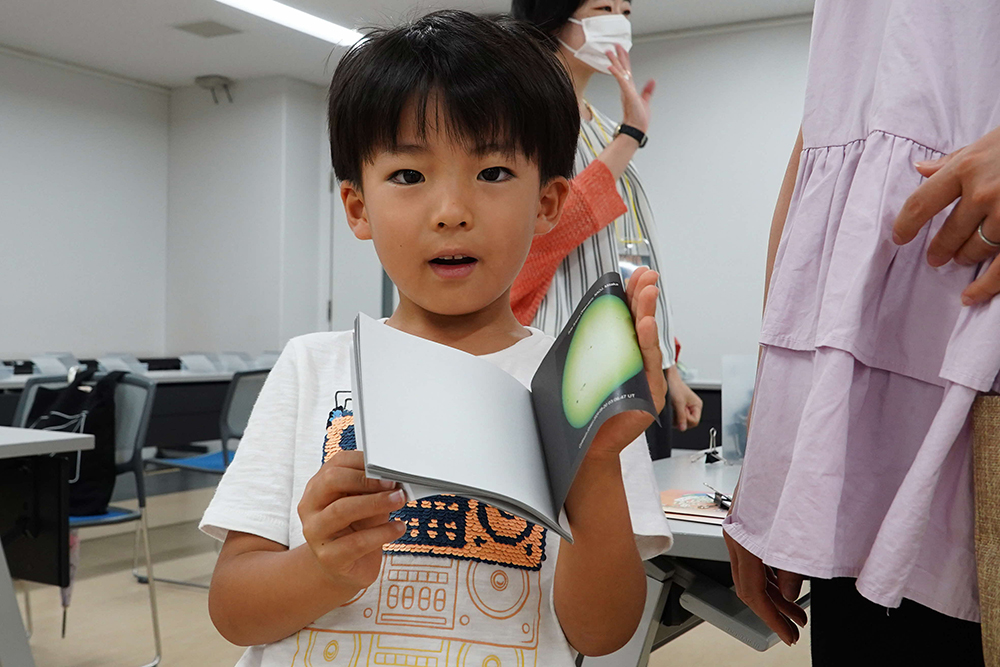 黒点パラパラまんがを見せる子どもの画像
