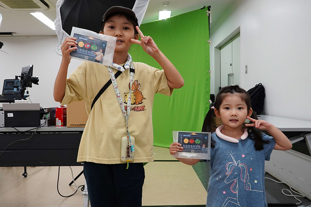 た宇宙天気予報士を体験できるフォトブースで記念撮影をする子どもの画像