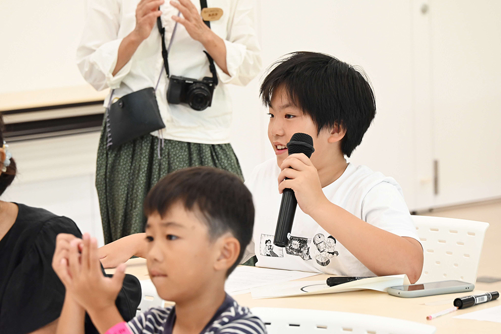 マイクで発表している写真