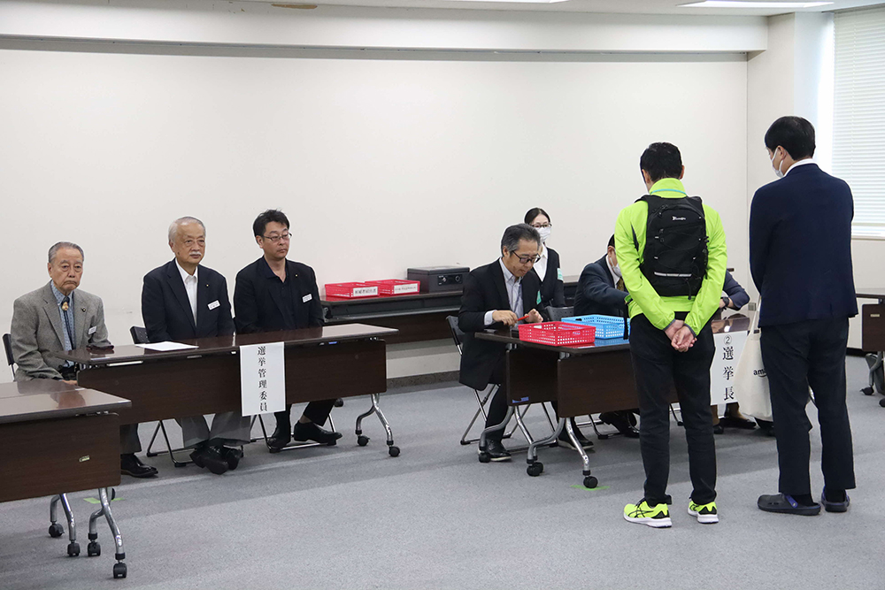 届け出を出す立候補者の後ろ姿の画像